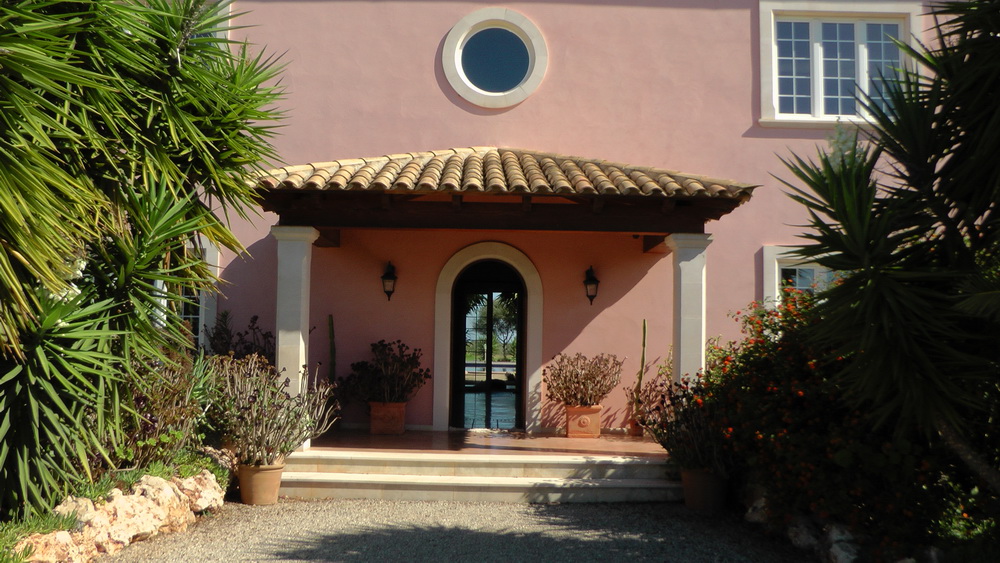 a pink building with a round window